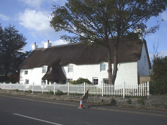 A white thatched house behind a picket fence in Bonvilston.