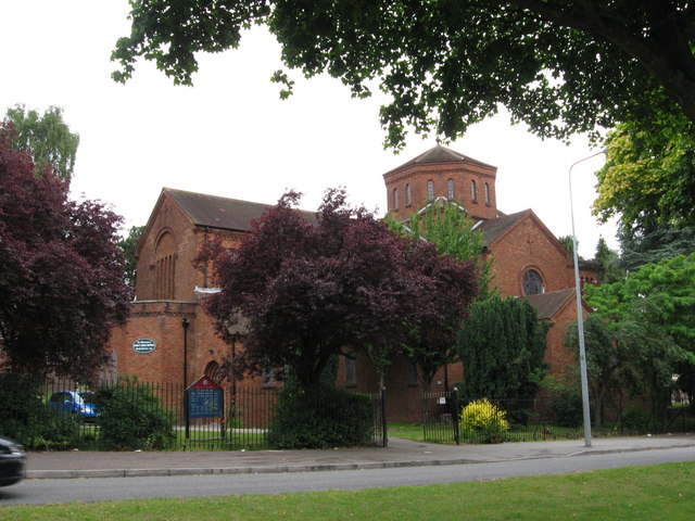 A red-brick church among trees in Ely, Cardiff.