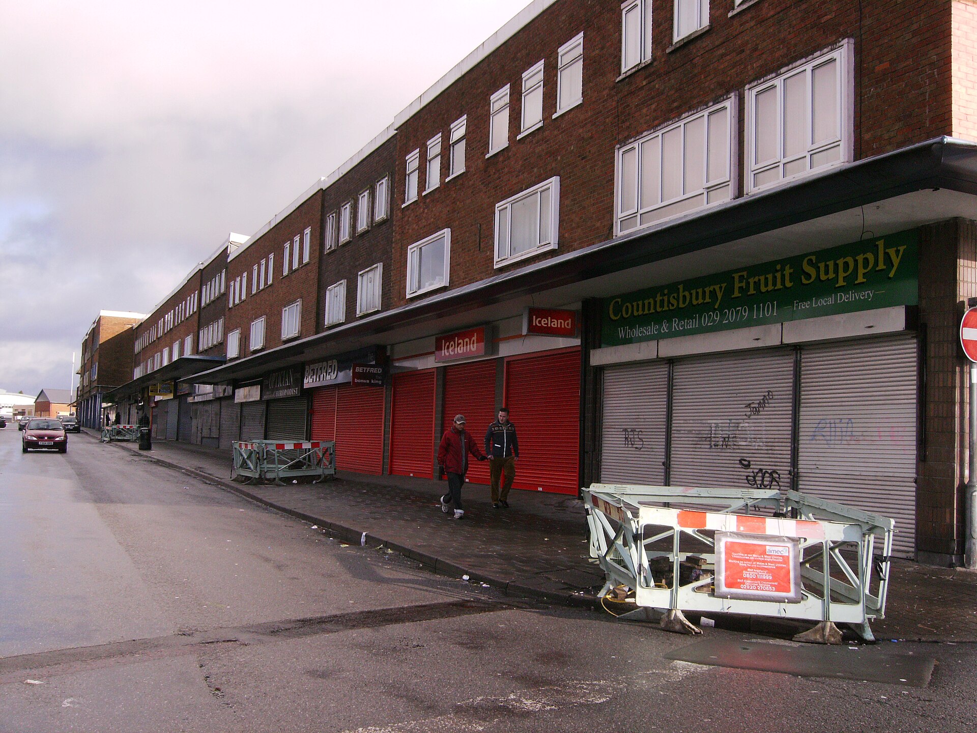 A parade of shops with their shutters down on Countisbury Avenue in Llanrumney.