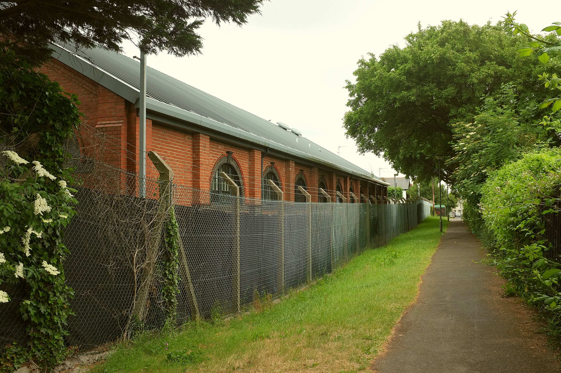 A footpath beside the brick buildings of Maindy Barracks.