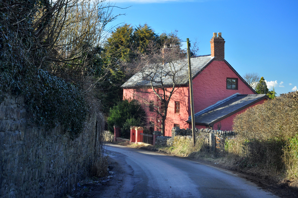 Ty Llwyd Farm, a pink farmhouse beside a narrow lane in Drope.