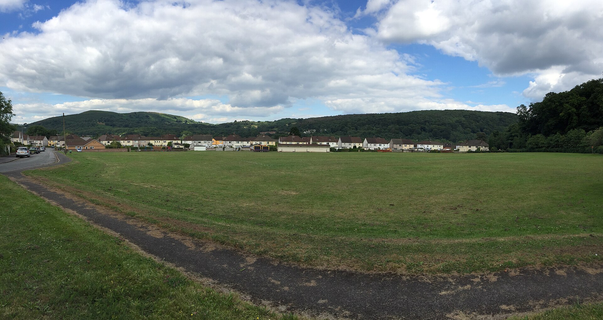 Georgetown Playing Field, an open grass field with houses and wooded hills beyond.