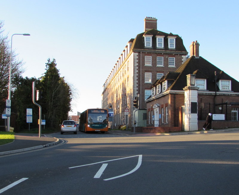 The entrance to Llandough Hospital with a bus turning at the junction.